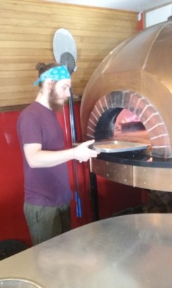 Dan Pizzutillo places pumpkin seeds at the edge of the oven at Nomad Pizza for a quick roast. 
